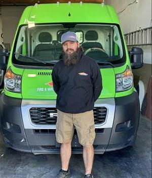 SERVPRO of Centennial Hills production tech JON standing in front of a work van.