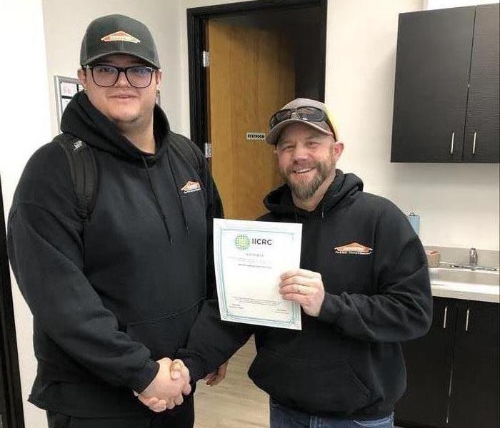 SERVPRO employee proudly showing his IICRC certificate 